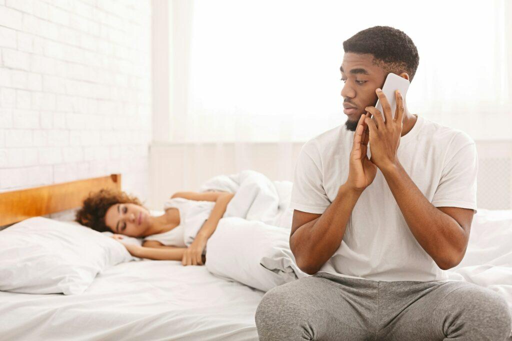 African man talking with mistress at home, hiding from his wife
