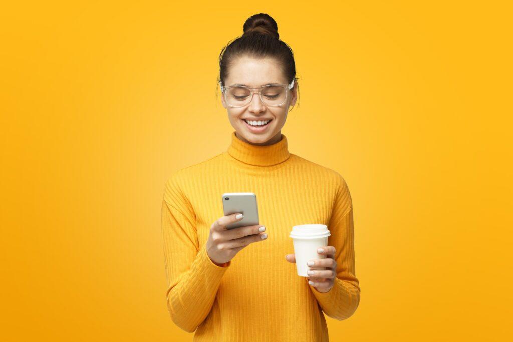 Attractive young good-looking European woman holds phone in hand texting