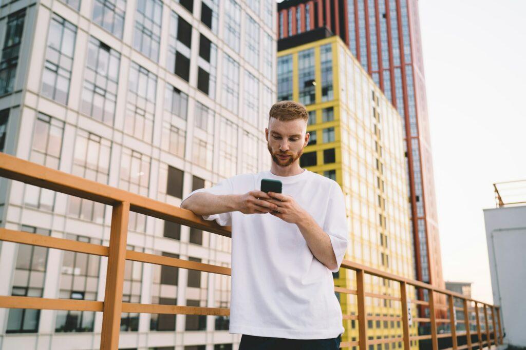 Young man using smartphone on building terrace