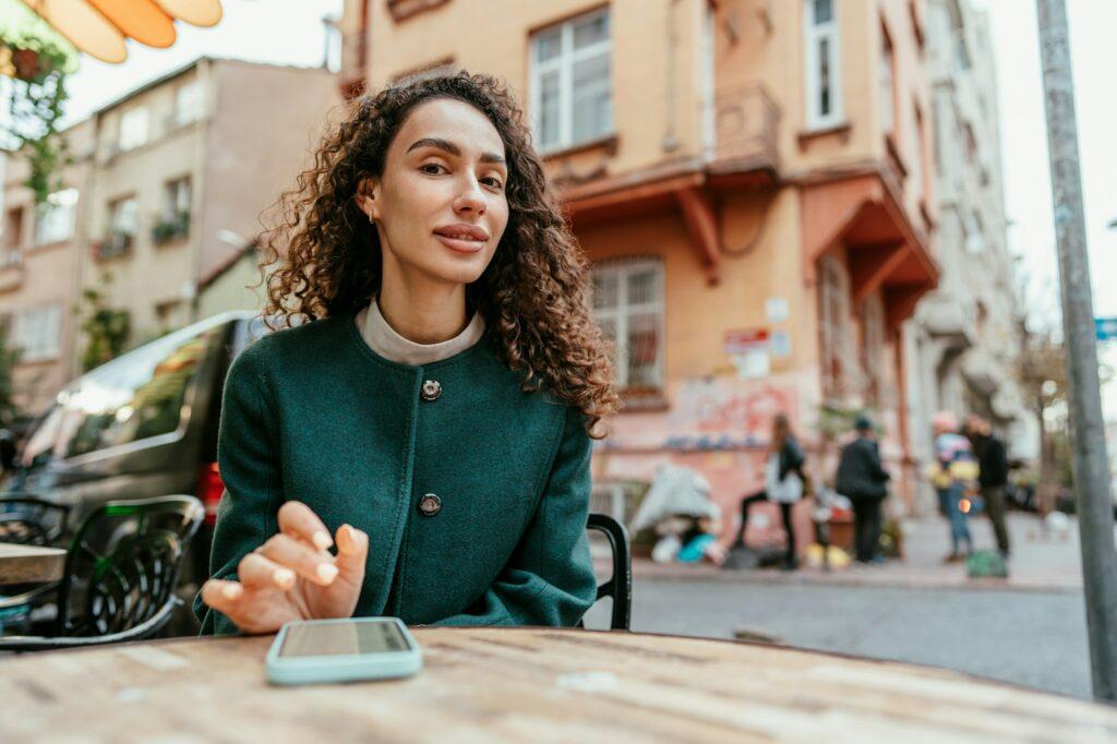 Young woman in a cafe reading a message from her mobile phone